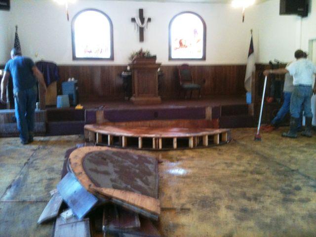 They've been busy in the sanctuary working on getting out all the damaged parts.  While the piano and electronics on the platform were ruined, the rest of the furniture appears to be salvagable - including the wooden rails from the custom made altar.